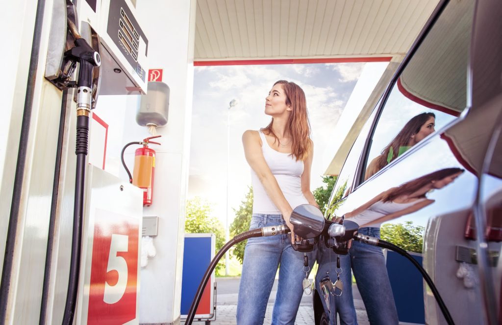 Pretty Young Woman Refuels the Car at a Gas Station