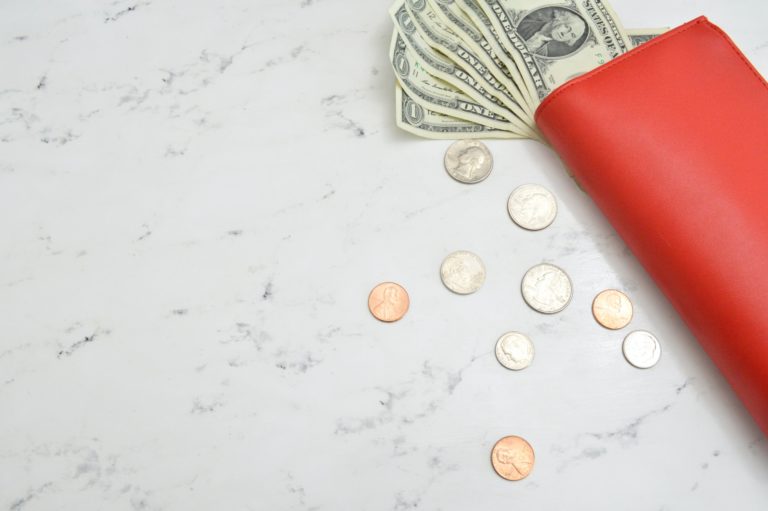 Coins and cash fallen out of a wallet on a table