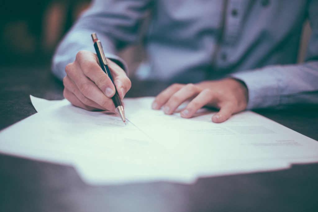 Man writing with pen on paper