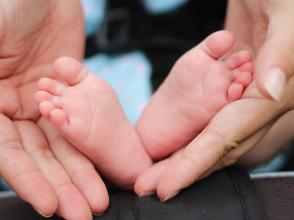 baby feet held by hands